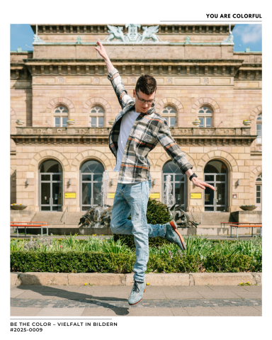 BE THE COLOR Puzzleteil #2025-0009 Junger Mann tanzt vor einem historischen Gebäude, trägt lässige Kleidung und Sneakers.